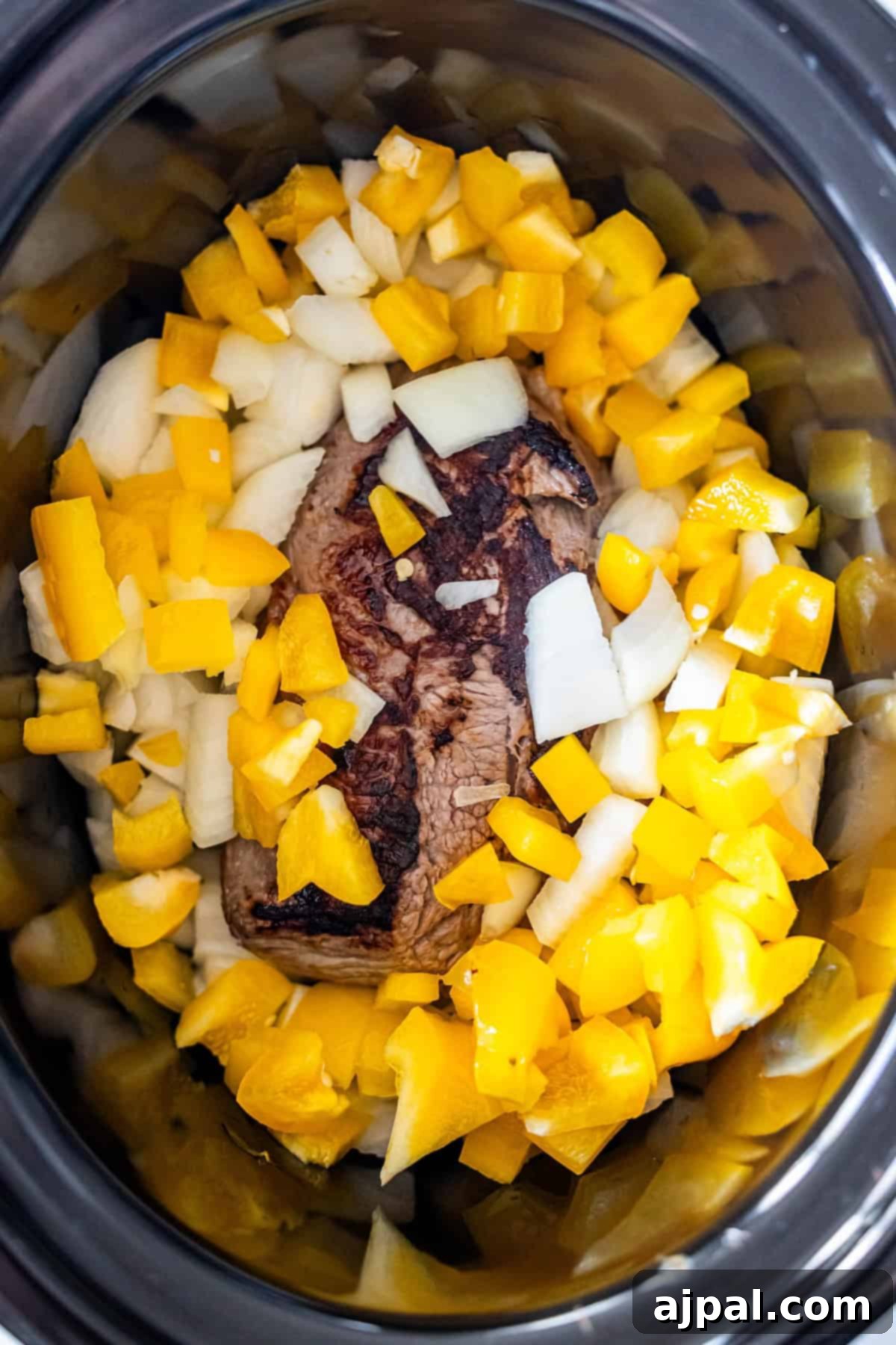 Browned sirloin steak topped with peppers and onions.
