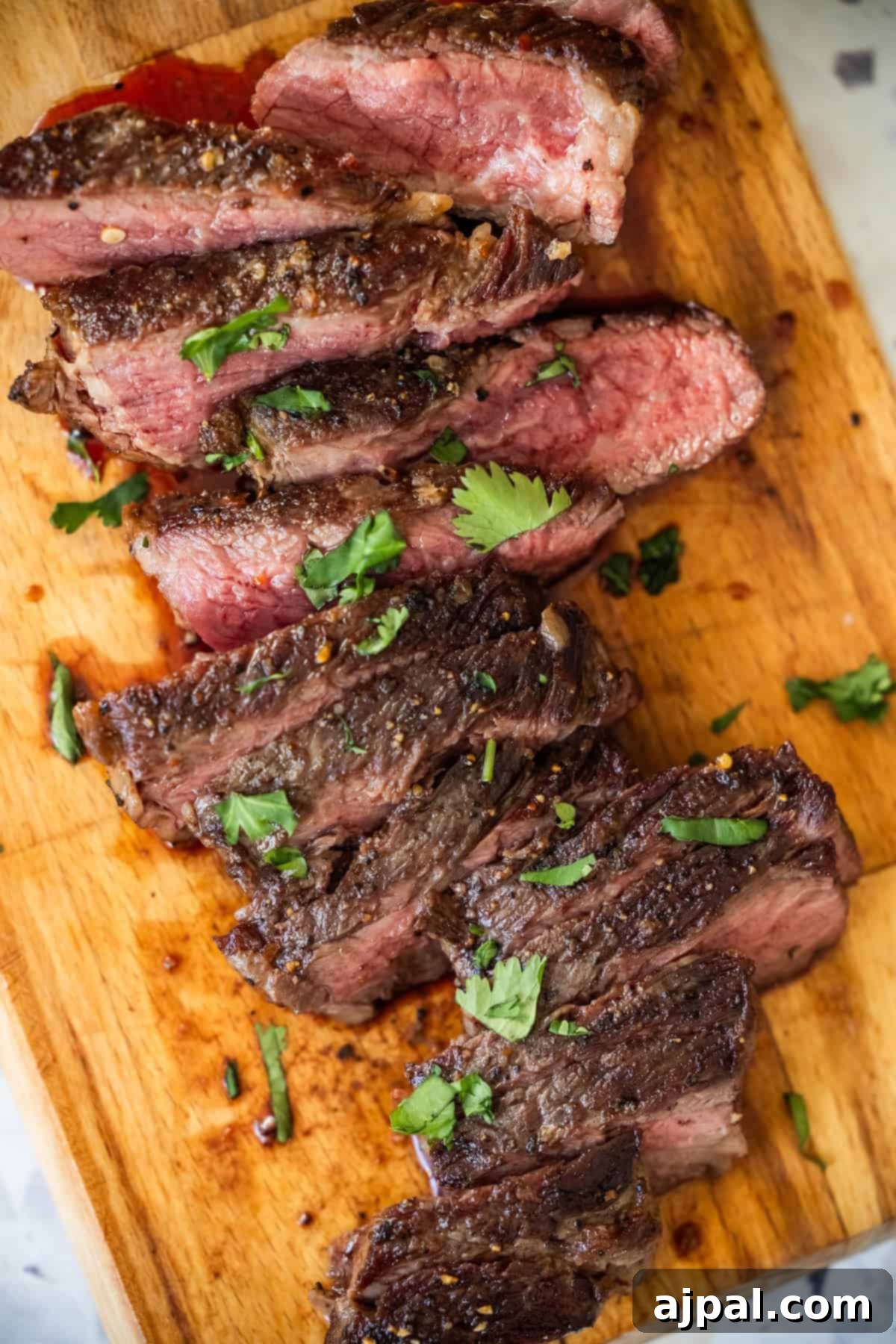 Denver Steak
Denver Cut Delight 2 Sliced medium-rare Denver Steak garnished with herbs on a cutting board