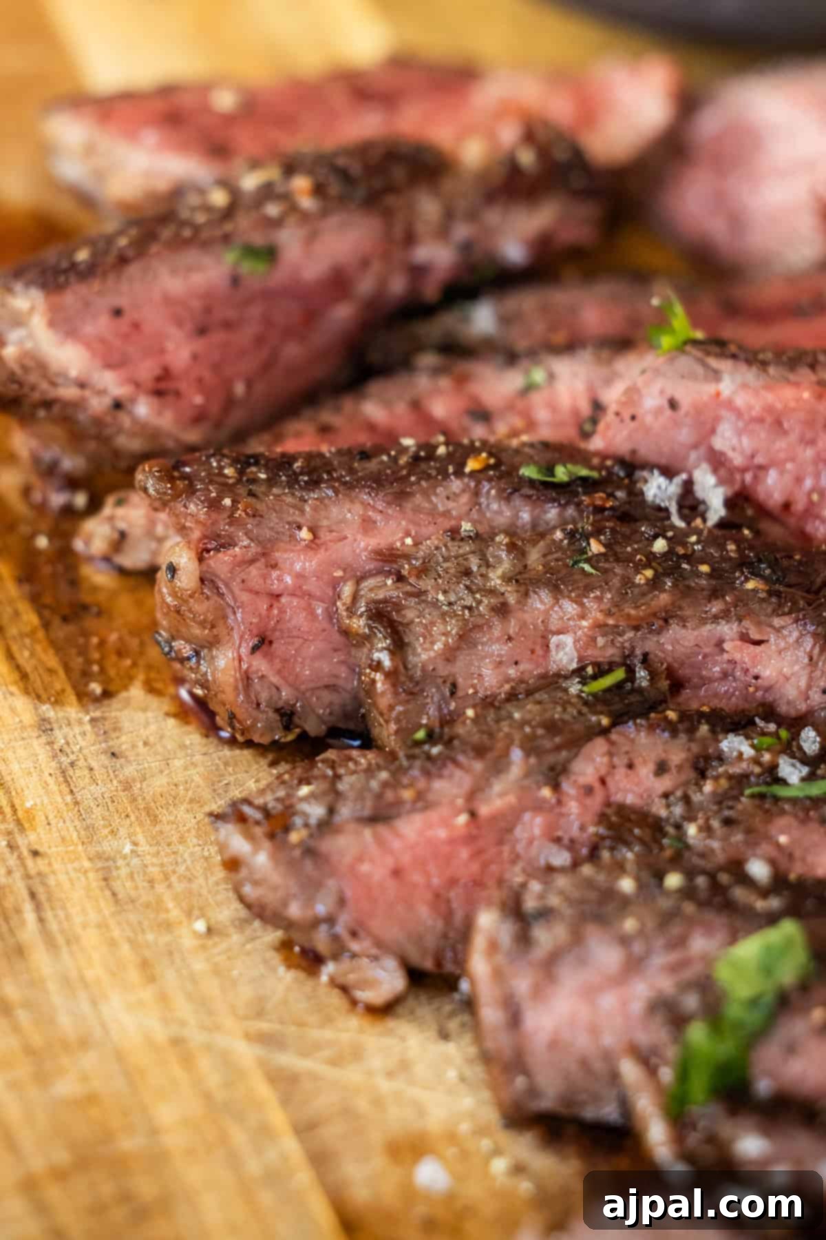 Sliced Denver Steak seasoned with salt, pepper, and herbs