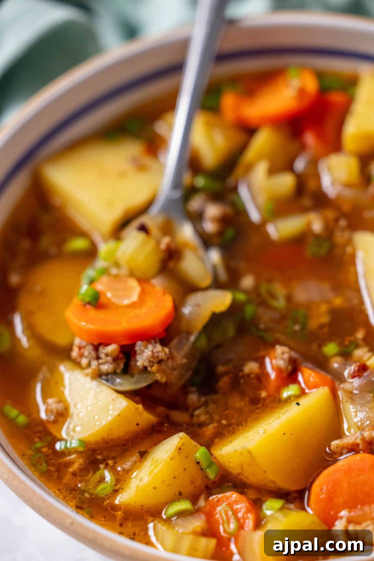 Sausage Vegetable Soup with spoon lifting a portion