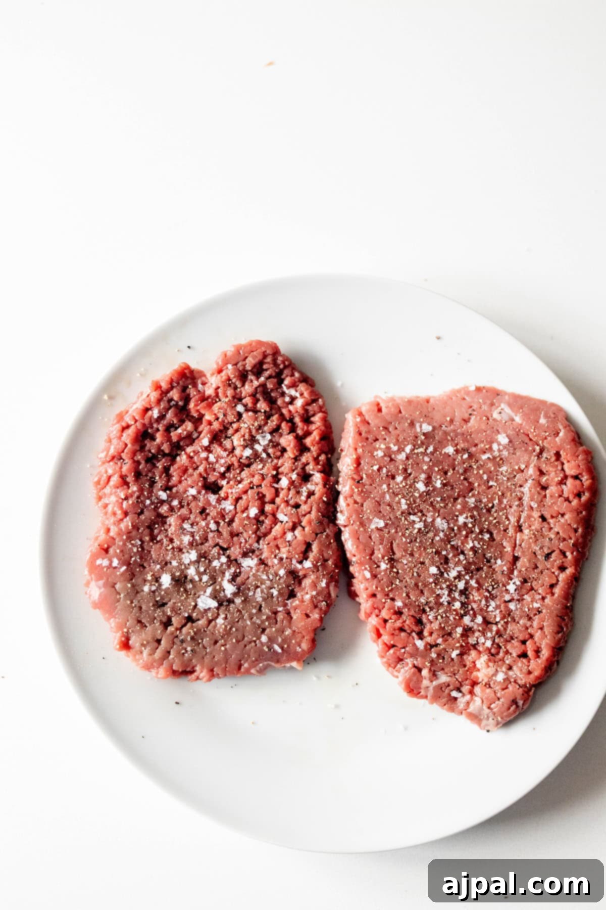 Country Steak in Gravy: A Hearty Homestyle Classic 6 Seasoned cube steak on a white plate.