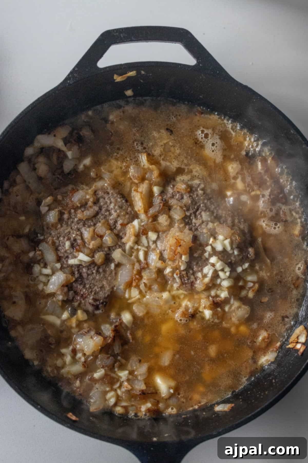 Country Steak in Gravy: A Hearty Homestyle Classic 10 Simmering steak and gravy in a skillet.