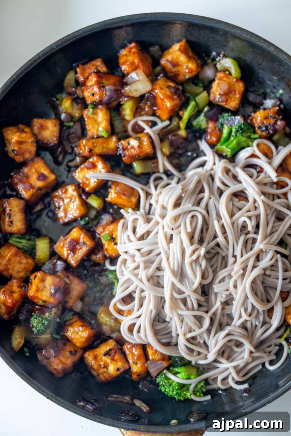 Cooked soba noodles added to the stir fry pan.