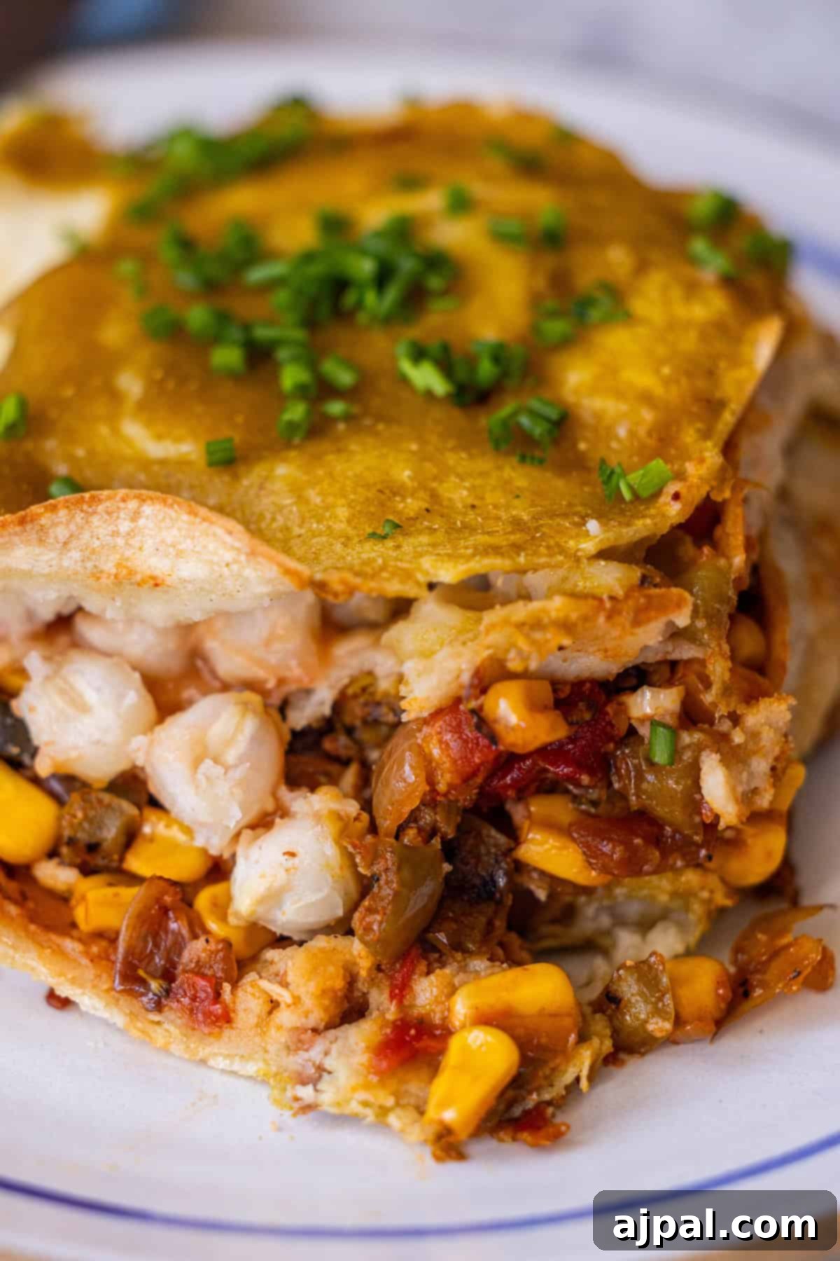 Sliced Vegan Enchilada Pie with vegetables and green sauce