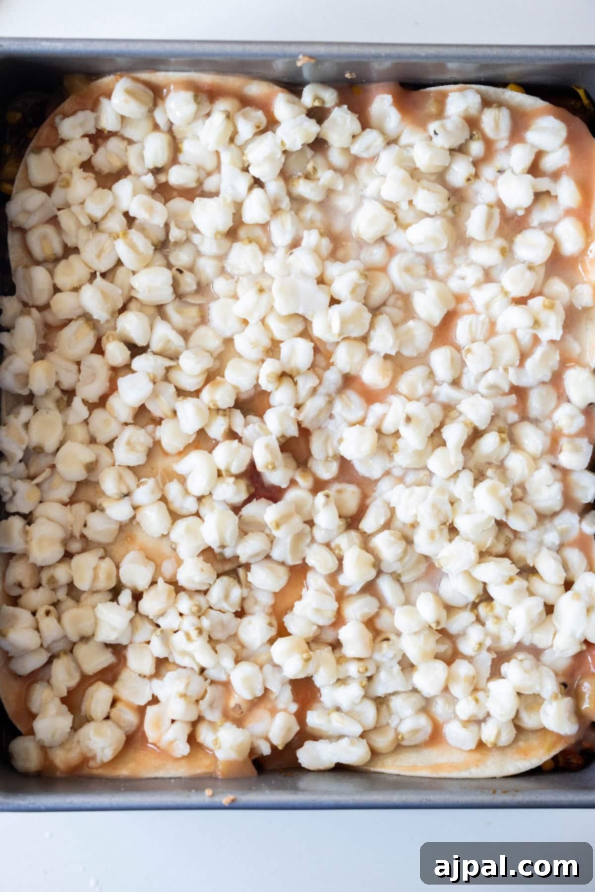Baking pan with hominy and sauce