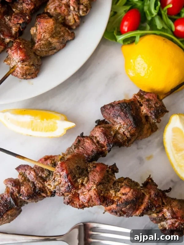 souvlaki skewers on a table with lemon wedges