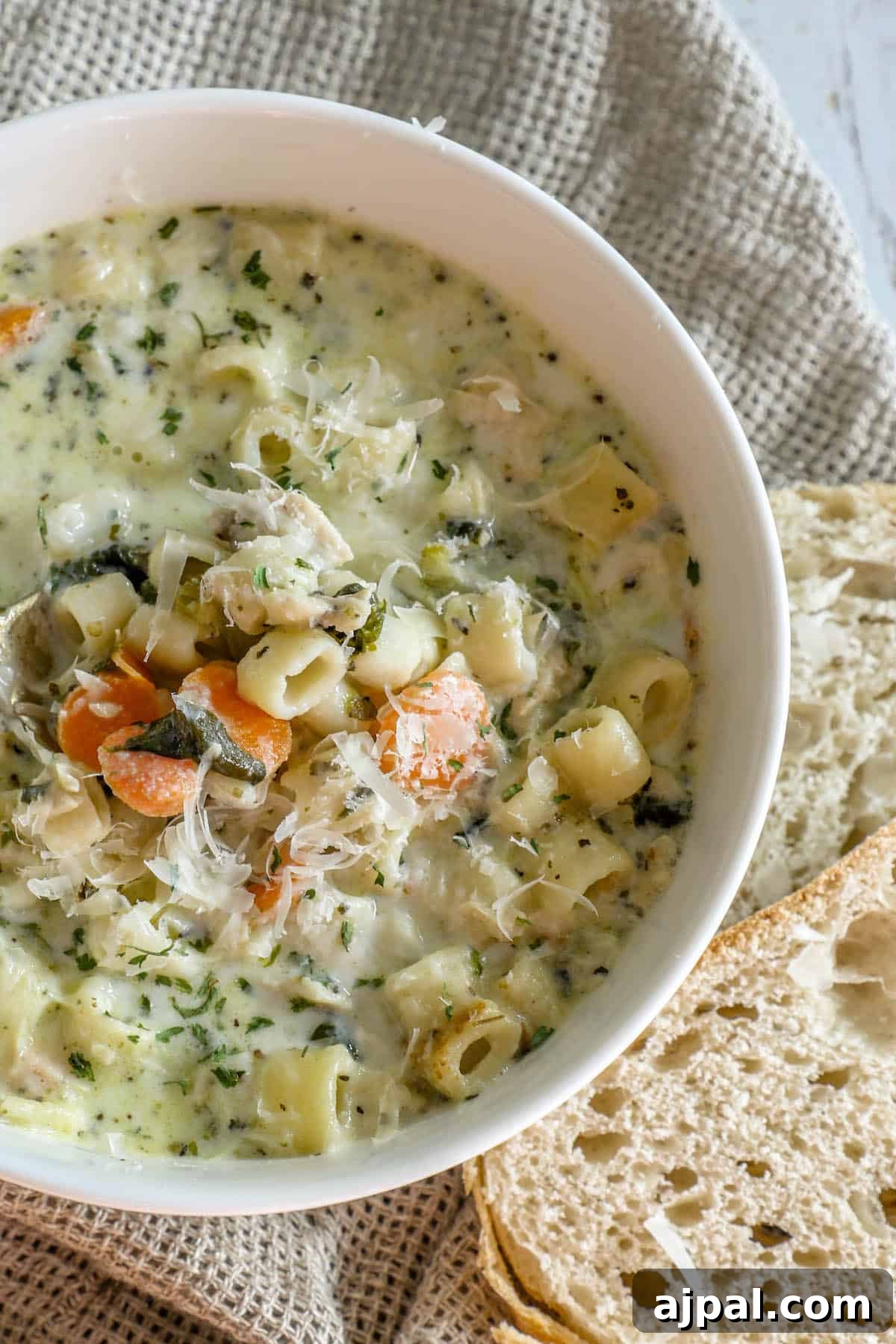 30 Back-to-School Meals That Reheat Perfectly 12 A creamy bowl of chicken noodle soup with bread next to it.